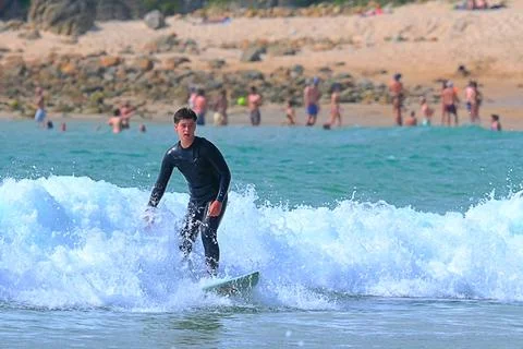 Surfer riding waves along dramatic coastline (29) ,27/08/2025 Stock-Fotos