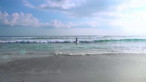 Surfer riding white-crested waves and moving out of sea to shore towards camera Video stock 73124683