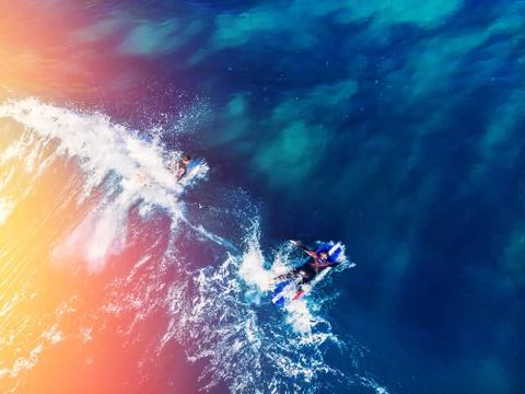 Surfer rows up to catch crest of wave in blue ocean sunlight. Concept surfing 写真素材