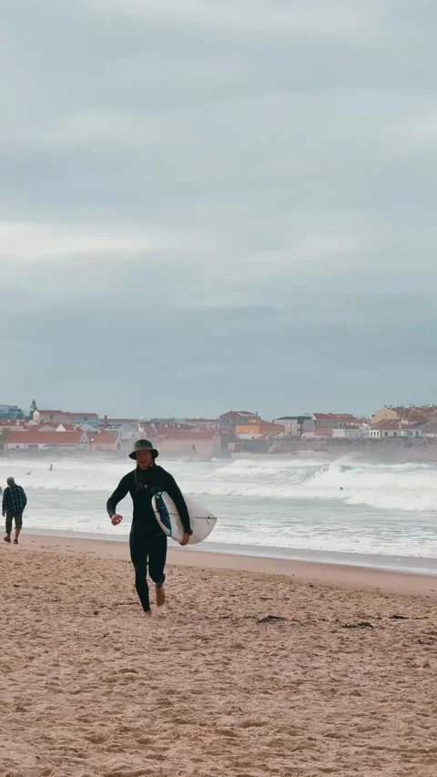 Surfer Running Back from Ocean to Beach. Stock Footage 328045356