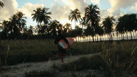 Surfer running to the beach rotating movement 스톡 동영상 307313104