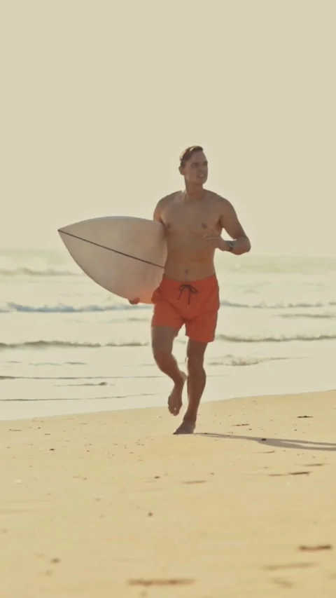 Surfer running on beach with surfboard Stock Footage 329136358