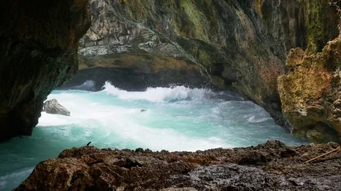 The surfer sails among the dangerous rocks of the bay. Stock-Footage 82530133