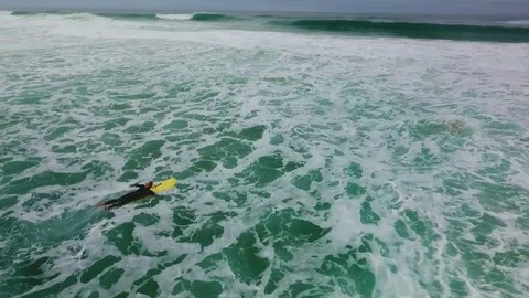 A surfer sails to meet the wave, the Atlantic Ocean, Portuga Stock Footage 76839475