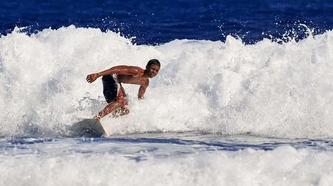 Surfer school. A young guy learning to stand on a surfboard. Surfer on the wa Stock Photos
