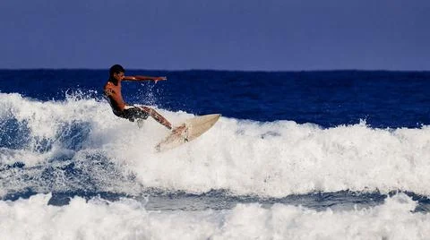 Surfer school. A young guy learning to stand on a surfboard. Surfer on the wa Stock Photos