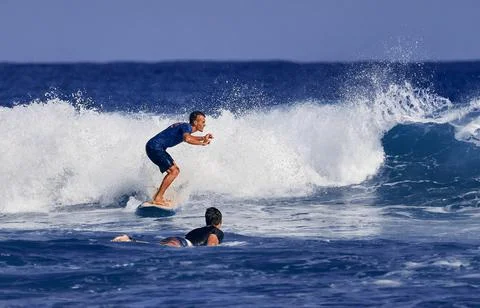 Surfer school. A young guy learning to stand on a surfboard. Surfer on the wa Foto stock