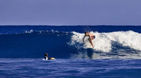 Surfer school. A young guy learning to stand on a surfboard. Surfer on the wave Stock Photos