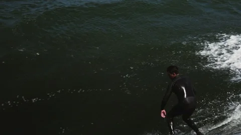 A surfer on a soft top surfboard rides a wave in Santa Cruz, California. Stock Footage 120678628