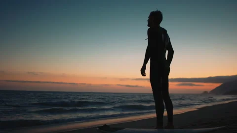 Surfer standing and watching sunset Video stock 136427767
