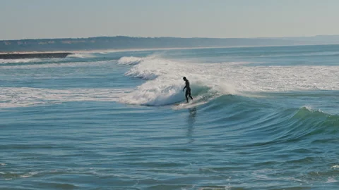 Surfer standing on a blue wave while surfing at the Atlantic Ocean Stock Footage 130626362
