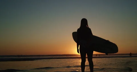 Surfer stands looking at waves during sunset Vídeo Stock 138336368