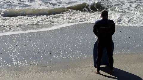 Surfer stands by the ocean Stock Footage 75062634