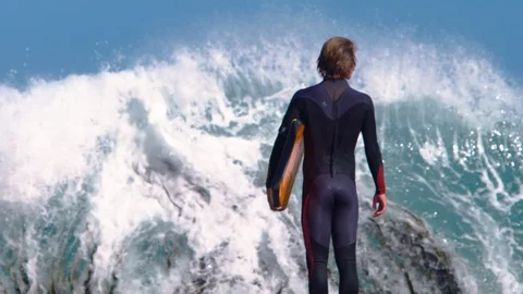 Surfer staring at dramatic wave crashing in slow motion in front of him. Stock Footage 87250906