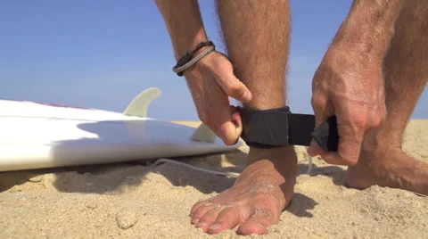 Surfer strapping a leash on his ankle Stock Footage 36640563