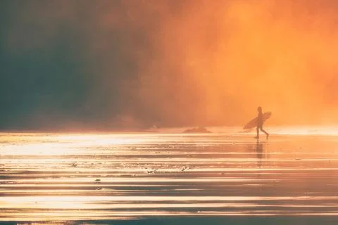 Surfer at the sunset with beutiful light Stock Photos