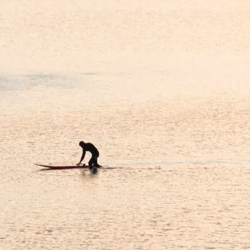 A surfer at sunset Stock Photos