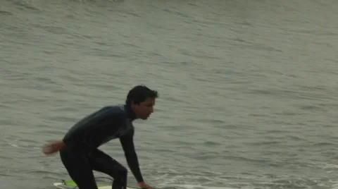 Surfer with Surfboard Climbing Out of Ocean in South America, long shot Stock Footage 48474473