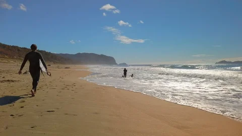 Surfer with surfboard in hand Walking On Sandy Beach in slow motion Stock Footage 109093338