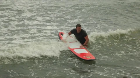 Surfer with Surfboard walking on rocks, leaving ocean 2 Video stock 48474544