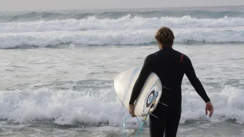 Surfer with surfboard walking in the sea Stock Footage 71540451
