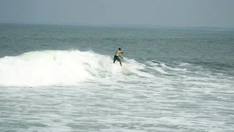 Surfer surfing waves on Bali beach in sunny day. Gimbal, tracking shot Stockbeeldmateriaal 217910397