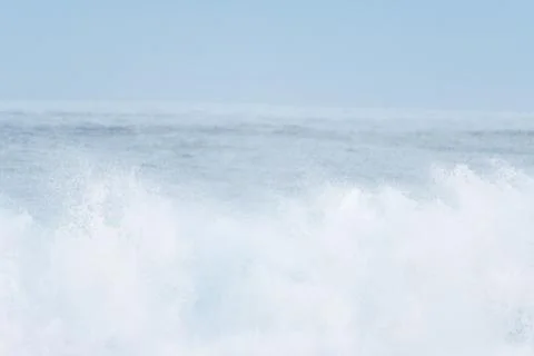 Surfer swallowed by a big wave on a beach on the north coast of Spain Stock Photos