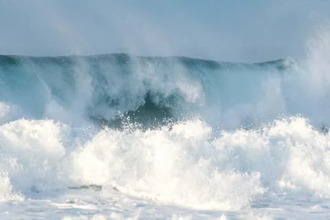Surfer swallowed by a big wave on a beach on the north coast of Spain Stock Photos