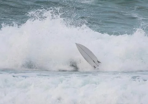 Surfer swallowed by a big wave on a beach on the north coast of Spain Stock Photos