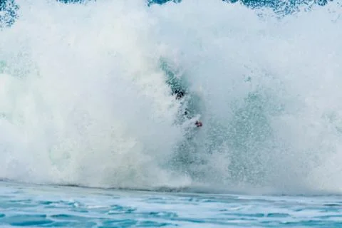 Surfer swallowed by a big wave on a beach on the north coast of Spain Foto stock