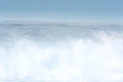 Surfer swallowed by a big wave on a beach on the north coast of Spain Stock Photos