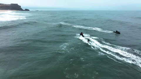 Surfer towed by jet ski through choppy ocean water Stock Footage 309001528