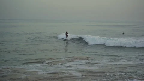 Surfer trying to catch a wave in taghazout anchor point on a half crowded spot Stock Footage 296658495