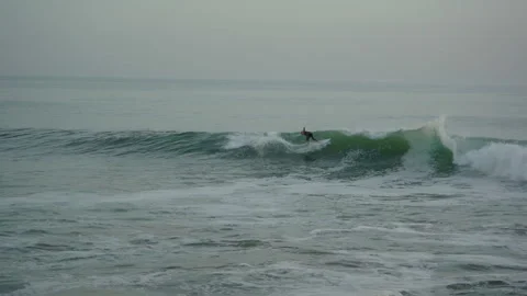 Surfer trying to catch a wave in taghazout anchor point on a half crowded spot Stock Footage 296659949