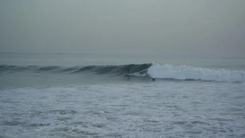 Surfer trying to catch a wave in taghazout anchor point on a half crowded spot Stock Footage 296659985