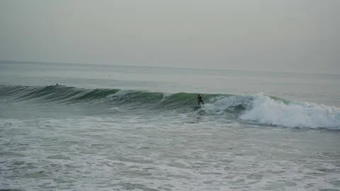 Surfer trying to catch a wave in taghazout anchor point on a half crowded spot Stock Footage 296660231
