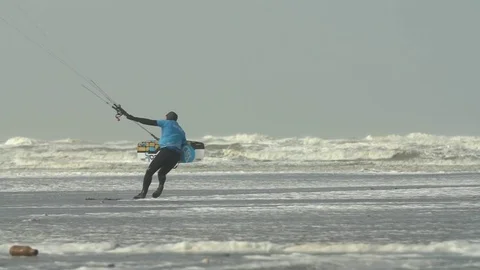 Surfer trying to take the floating parachute to the sea to surf Stock Footage 77805010