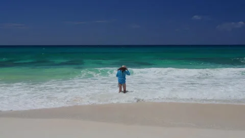Surfer wading into ocean waves on tropical beach Stock Footage 346368601
