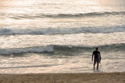 Surfer wading out for a surf Stock Photos