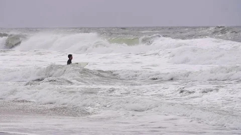 Surfer waiting for the approaching waves to surf in sea in slow motion Stock Footage 71566197