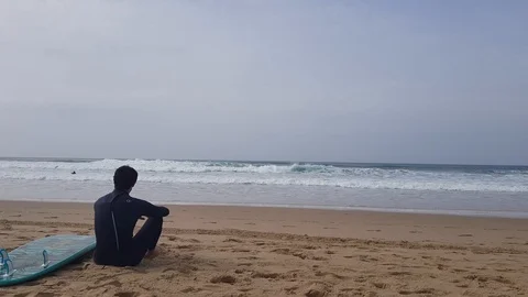 Surfer waiting on the sand tide 動画素材 103204000
