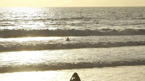 Surfer waiting wave in ocean at sunset in slow motion Stock Footage 83698597