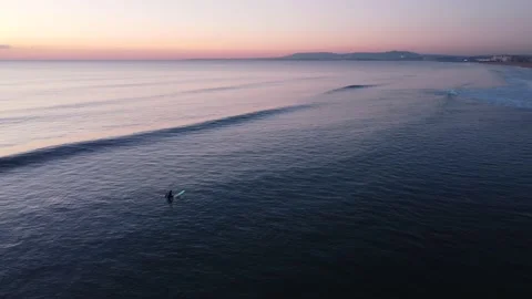 Surfer waiting Waves during Sunset at Costa da Caparica beach, Portugal Stock Footage 146102565