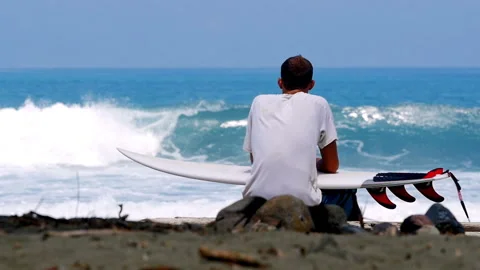 Surfer waiting for waves on a tropical beach Stock Footage 336896150