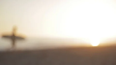 Surfer walking across beach during sunset, out of focus, dream like Video stock 116852539