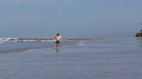 Surfer Walking Up The Beach After A Session Stock Footage 107609687