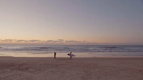 Surfer is walking on the beach during sunset in Tel Aviv. Stock Footage 98213872