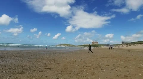 Surfer walking on beach with surf board toward the sea, Fistral, Newquay Stock Footage 65440935