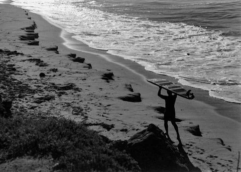 Surfer walking with board overhead. Stock-Fotos