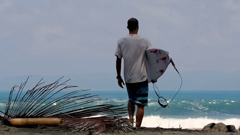 Surfer walking with board towards ocean waves at beach Stock Footage 336896078